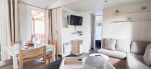 ein kleines Wohnzimmer mit einer Couch und einem Tisch in der Unterkunft Naphtase MH01S Le Refuge des Pins in Saint-Jean-de-Monts