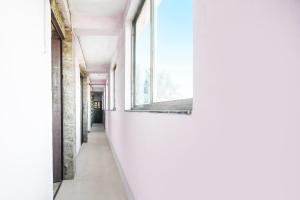 an empty corridor in a building with a window at Hotel O SUKOON in Dhanbād
