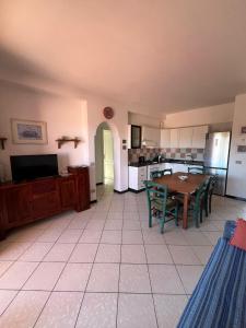 a kitchen and dining room with a table and chairs at Le Canne - Appartamento "Sole" in San Teodoro