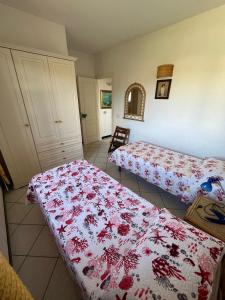 a bedroom with two beds with a red and white blanket at Le Canne - Appartamento "Sole" in San Teodoro +8 photos