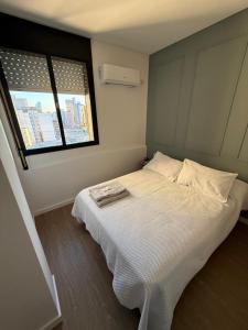 a bedroom with a white bed and a window at Departamento Sancor in Santa Fe