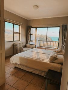 a bedroom with a large bed with a view of the ocean at Wild Bay - Hole in the Wall Resort in Coffee Bay +12 photos