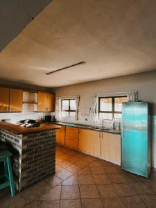 Il comprend une grande cuisine avec un réfrigérateur bleu. dans l'établissement Wild Bay - Hole in the Wall Resort, à Coffee Bay