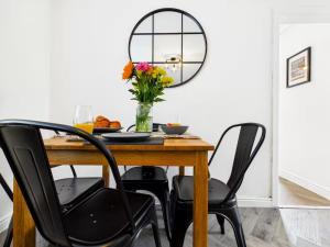 a dining room table with a mirror and a vase of flowers at 4 Bed House Port Talbot - Perfect For Contractors in Port Talbot +49 photos