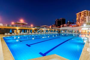 una gran piscina por la noche con sillas en Aydinoglu Hotel, en Estambul