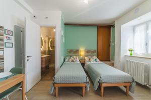 two beds in a room with a bathroom at Casa Vacanze IL GELSOMINO in Valfabbrica