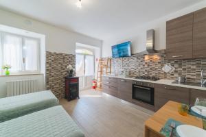 a living room with a kitchen with a stove top oven at Casa Vacanze IL GELSOMINO in Valfabbrica +22 photos