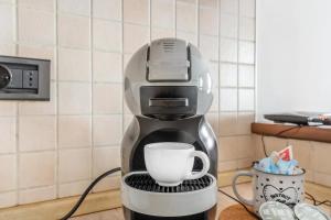 a coffee maker with a cup on a stand at New - RhoFiera Milano - 5 min Free Wi-Fi in Rho