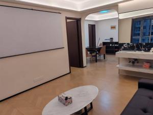 a living room with a large white screen and a table at Fenghe Cottage 