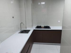 a white kitchen with a sink and a stove at Fenghe Cottage 