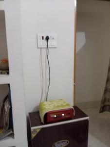 ein Radio, das auf einer Kiste in einem Zimmer steht in der Unterkunft Aadha vatika in Deoghar