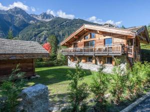 a log cabin with a balcony and a house at Chalet à Chamonix avec Sauna et Jacuzzi - FR-1-343-253 in Chamonix-Mont-Blanc