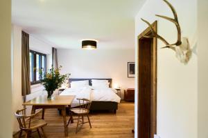 a bedroom with a bed and a table and chairs at Tilli´s Garten in Scharnitz