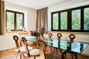 a dining room with a glass table and chairs at Tilli´s Garten in Scharnitz