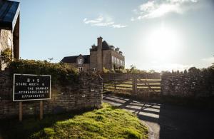a sign in front of a stone wall with a building at Stone House Wales in Kington