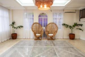 a room with three wicker chairs and a chandelier at MiraNamin M A P I L I G Suite in Unique Historic Home - Shared Kitchen, Rooftop in Manila