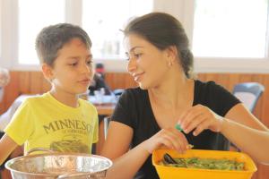 a woman and a boy eating food in a bowl at KiDRAK OTEL MONTENEGRO-1 in Faralya