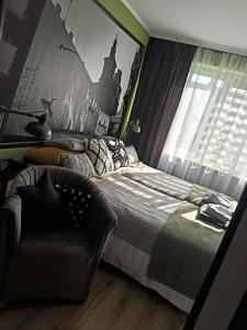 a bedroom with a bed and a chair at Apartament Przemyśl in Przemyśl +12 photos