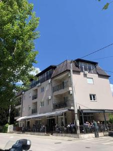 a large building with people sitting outside of it at Apartment Aluna 3 in Višegrad