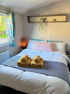 a bed with two towels on top of it at Lovely 3 bedroom holiday home in Seton Sand caravan park Wi-Fi Xbox in Longniddry
