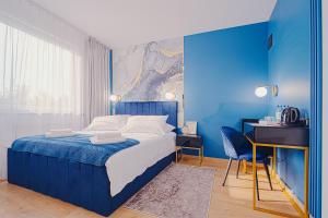 a blue bedroom with a bed and a desk at Hotel 500 W Strykowie in Stryków +53 photos
