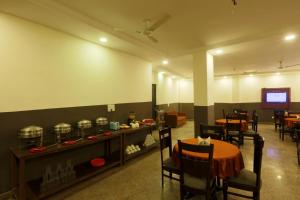 Un comedor con mesa y sillas y un televisor. en Elite blue one, en Nueva Delhi