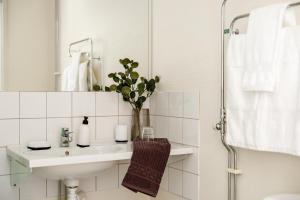 ein Badezimmer mit Waschbecken und einer Blumenvase in der Unterkunft Hotell Säsong - Boden Business Park in Boden