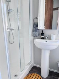 a bathroom with a sink and a shower at Lovely 3 bedroom holiday home in Seton Sand caravan park Wi-Fi Xbox in Longniddry