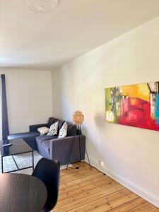 Una sala de estar con un sofá y un cuadro en la pared. en Cozy 2-Bedroom apt, en Bronshoj