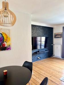 sala de estar con mesa y TV de pantalla plana en Cozy 2-Bedroom apt, en Bronshoj