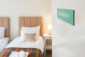 a hotel room with a bed and a sign on the wall at Glenbruar House in Crianlarich