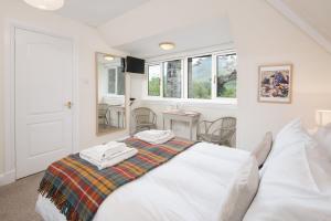a bedroom with a bed with towels on it at Glenbruar House in Crianlarich