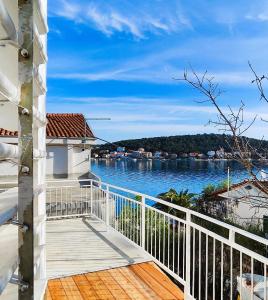 Un balcón de una casa con vista al agua. en Apartmány Tisno Marina, en Tisno