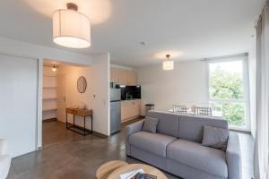 ein Wohnzimmer mit Couch und Küche in der Unterkunft Studio proche de Genève in Saint-Julien-en-Genevois