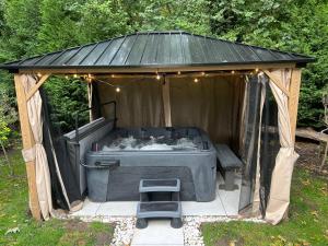 a gazebo with a hot tub in the yard at Airport Hideaway in Manchester