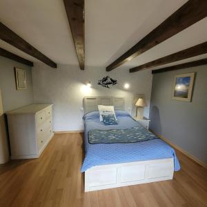 a bedroom with a bed with a blue comforter at la Marcairie in La Bresse
