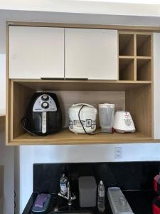 a kitchen shelf with various appliances on it at Apartamento lindo diamond 915 independência in Juiz de Fora