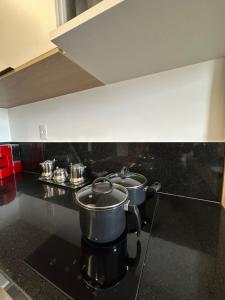 three pots on a stove in a kitchen at Apartamento lindo diamond 915 independência in Juiz de Fora +2 photos