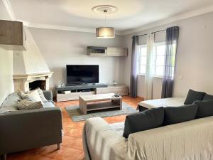 a living room with two couches and a tv at Casa Miramar in Tavira