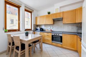 a kitchen with wooden cabinets and a table with chairs at GRAND ADVENTURE BUDAPEST in Budapest