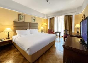 a hotel room with a large bed and a desk at Radisson Hotel Kathmandu in Kathmandu