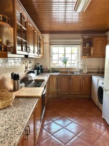 a kitchen with wooden cabinets and a counter top at Casa Miramar in Tavira