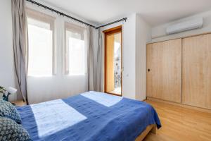 a bedroom with a blue bed and a window at GRAND ADVENTURE BUDAPEST in Budapest