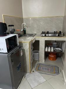 ディアニ・ビーチにあるSunQuine Studioのシンクと電子レンジのある小さなキッチン