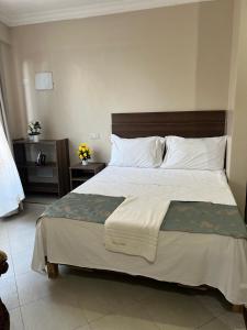 ディアニ・ビーチにあるSunQuine Studioの木製のヘッドボードが付いた大きなベッドのある寝室