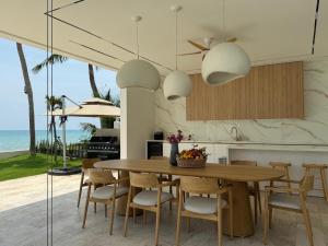 eine Küche und ein Esszimmer mit Tisch und Stühlen in der Unterkunft Euphoria Samui Beachfront Luxury Villa in Ban Laem Din