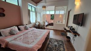 a bedroom with a bed and a tv in a room at Sha Ri Loum Homestay in Shillong