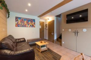 a living room with a leather couch and a table at Chalet Triplex avec Piscine - Sauna in Samoëns