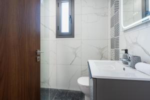 a bathroom with a sink and a toilet and a mirror at Vervana 2-Bedroom Apartment in Larnaca