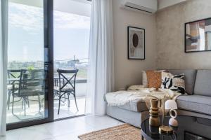 a living room with a couch and a balcony at Vervana 2-Bedroom Apartment in Larnaca +8 photos